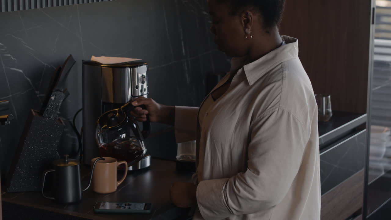 Woman pouring coffee in kitchen