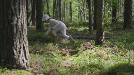 una niña pequeña está recogiendo arándanos en un bosque durante el verano en cierres blancos