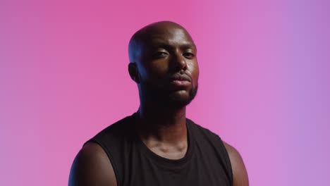 Studio-Portrait-Shot-Of-Male-Athlete-Wearing-Sports-Vest-Against-Pink-Lit-Background-1