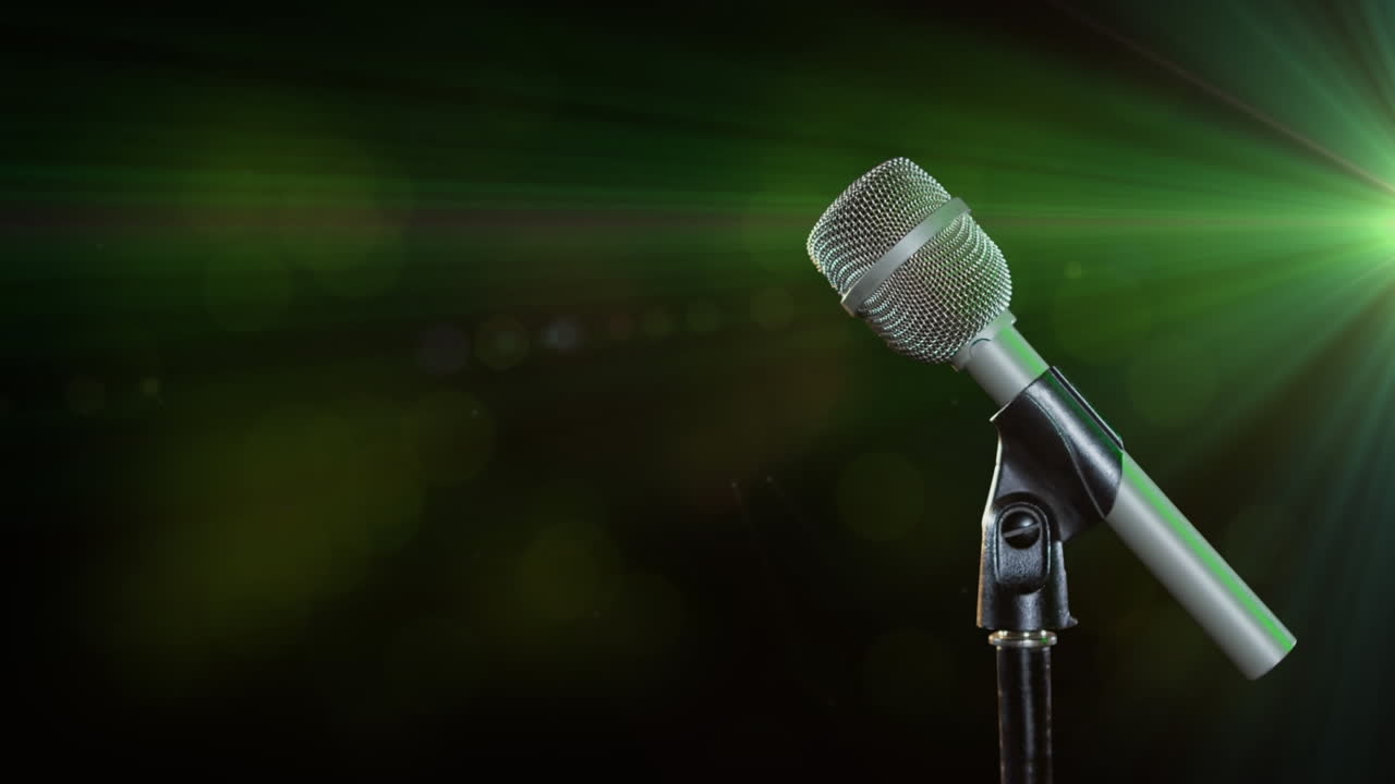 micrófono contra un punto verde de luz sobre un fondo negro