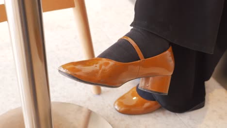 woman's orange shoes at a cafe