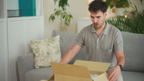 happy man unpacks courier parcel