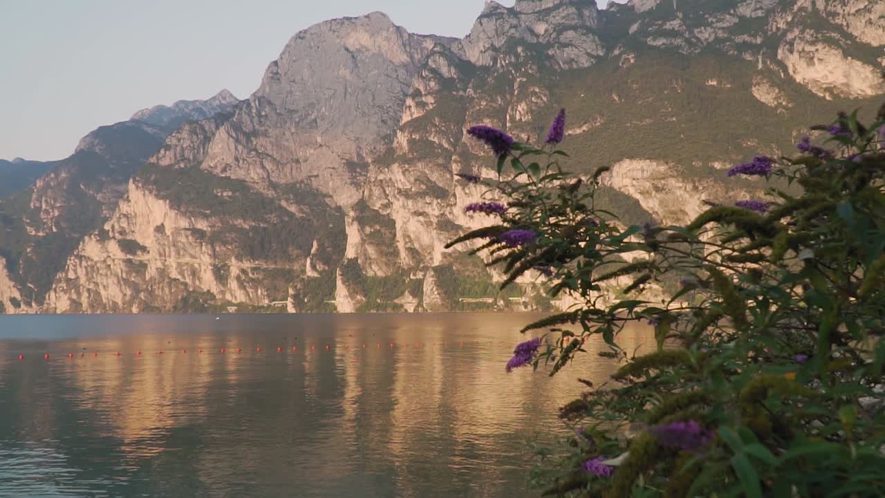 Majestic mountains mirrored in calm water of Lake Garda, quiet morning scenery