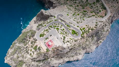 Aerial-descend-over-Formentor-Lighthouse-tower-and-serpentine-road,-Mallorca