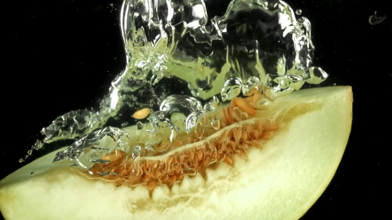 Fresh Melon Slice Falling into Water with Splashes