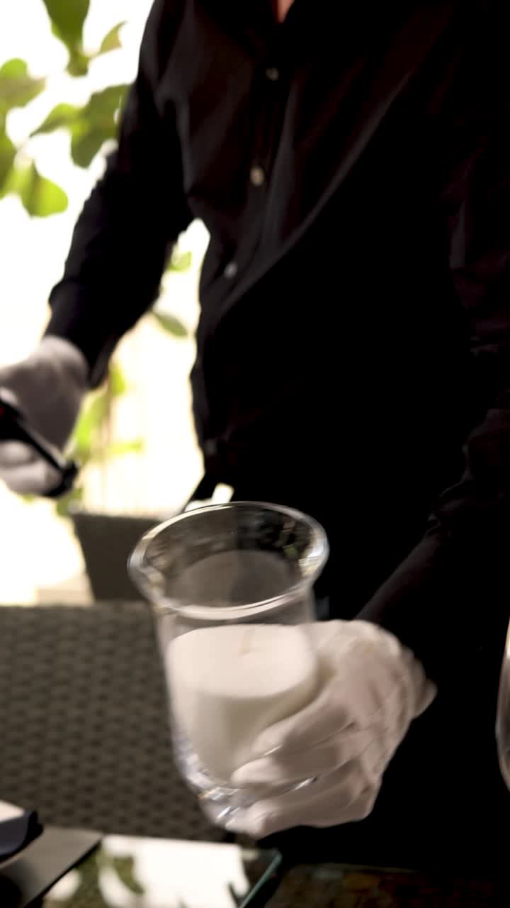 Waiter lighting a candle in a vase at a restaurant