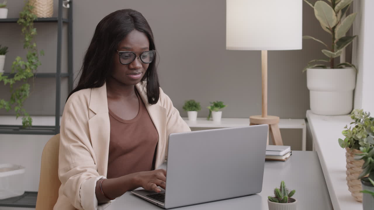 Woman working on laptop in a home office.