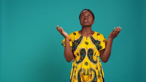 Religious-optimistic-girl-praying-to-God-for-good-fortune-in-studio