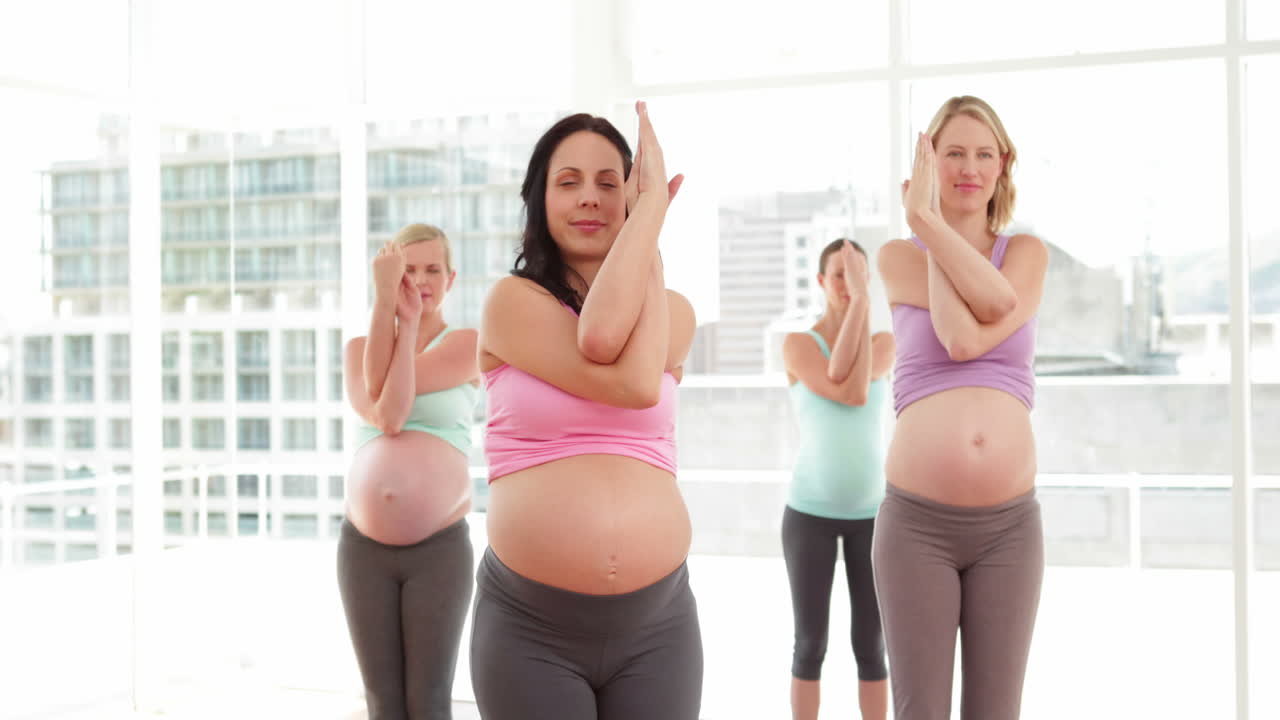 Donne incinte che fanno yoga in uno studio fitness