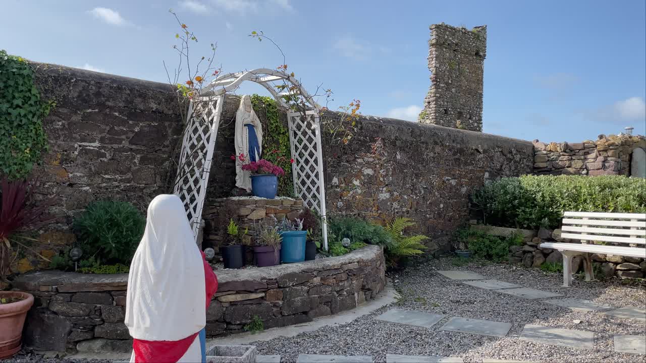 estatua de una niña orando a nuestra señora en una gruta en el pueblo de killea waterford en un día soleado