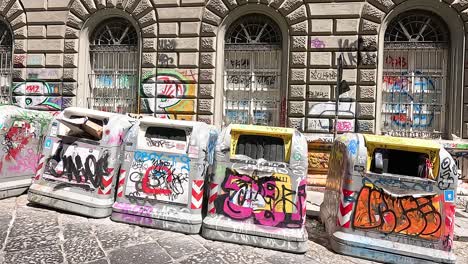 trash bins with graffiti in naples, italy