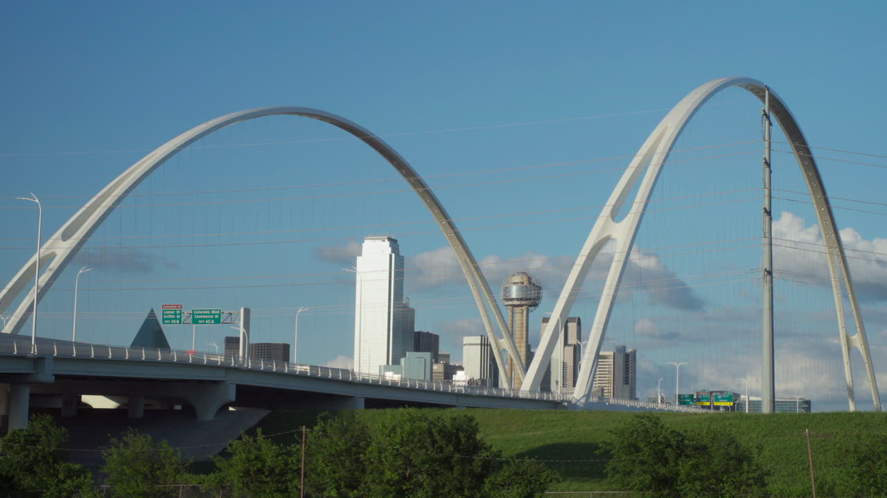 4k - el horizonte de dallas está enmarcado por los dos arcos del puente margaret mcdermott con la icónica torre de reunión en el centro