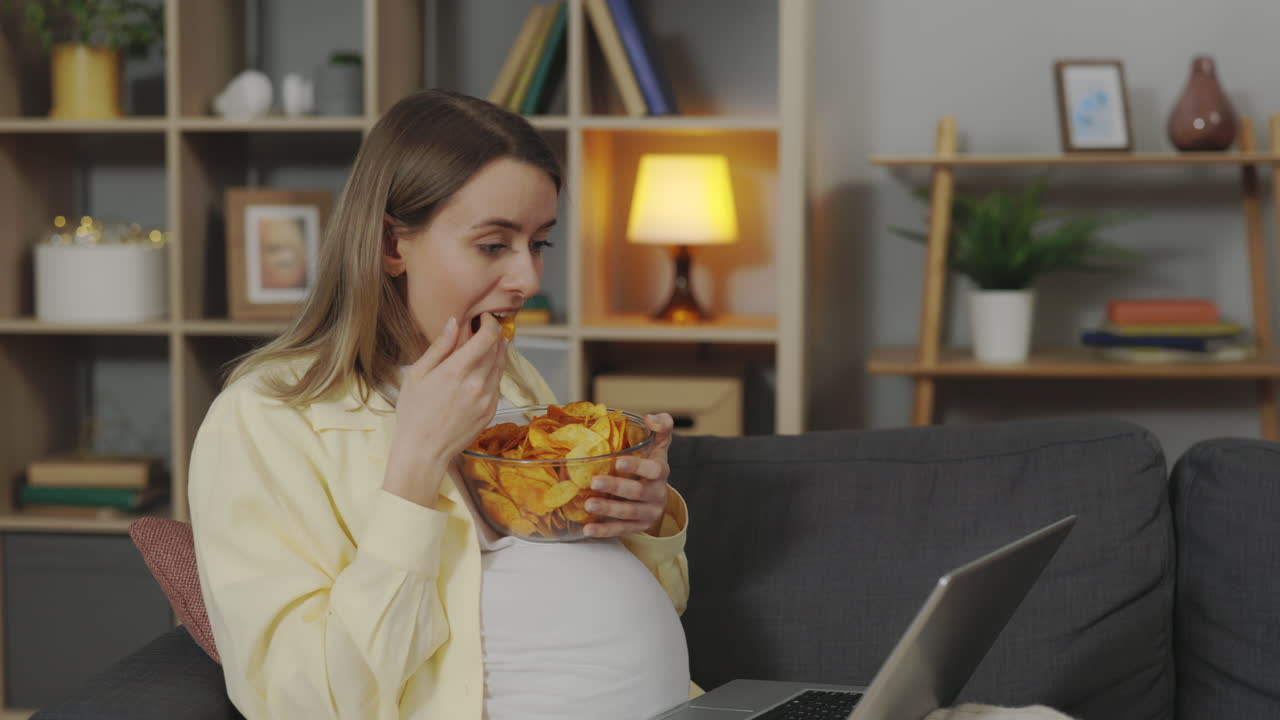 Pregnant Woman Snacking and Working from Home