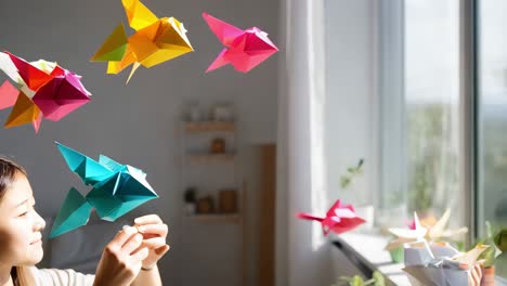 child creating colorful origami fish