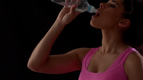 fit woman in pink drinking water