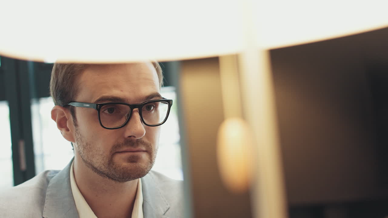 Male eyes in eyeglasses in front of laptop coder programmer or developer using laptop close up of