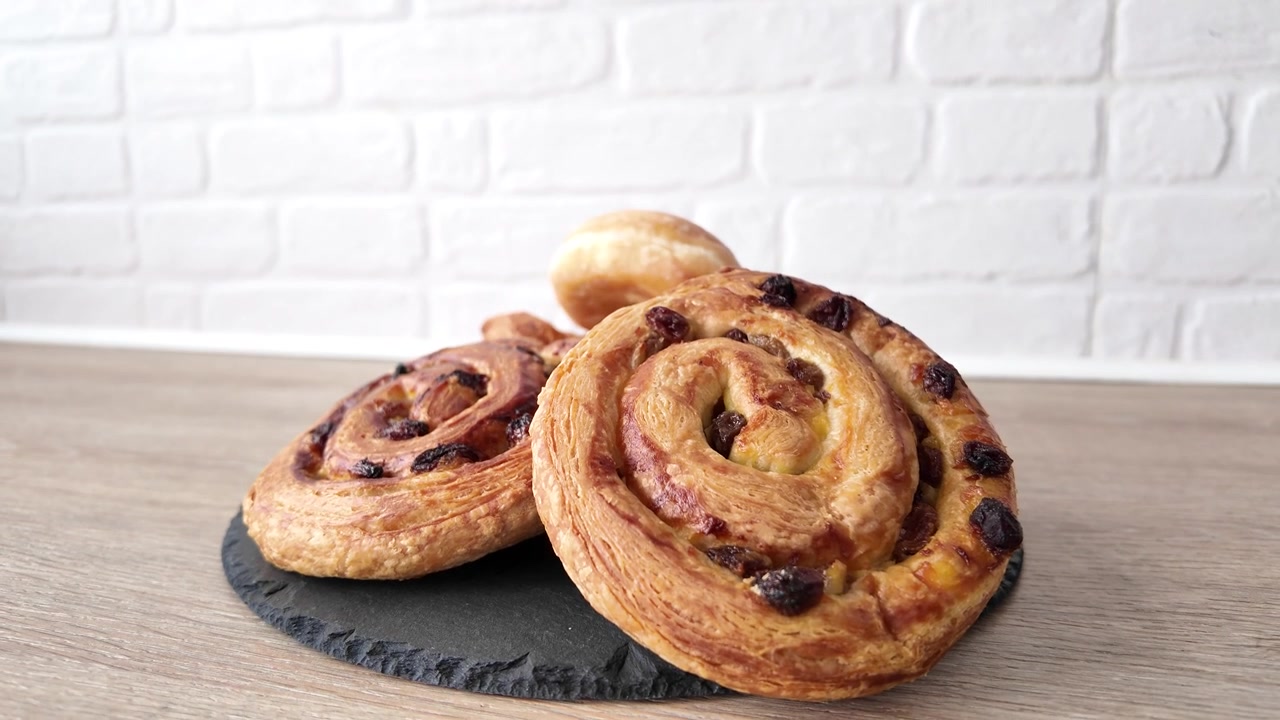 Mano che prende un croissant fresco da una selezione di pasticceria