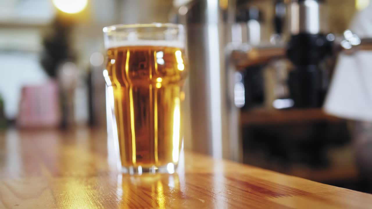 Un uomo paga una birra con uno smartwatch al bancone di un bar