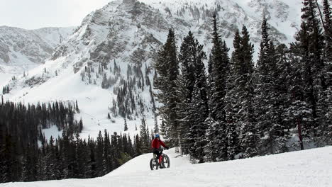fat biking up hill in the mountains on the snow