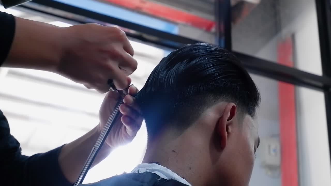 primer plano de peluquero corta el cabello con tijeras en la barbería
