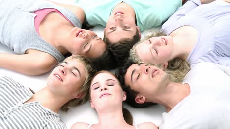 adolescentes tendidos en el suelo con las cabezas juntas