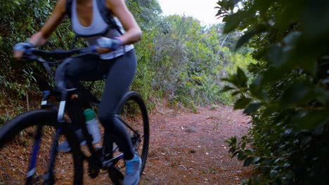 Female-cyclist-cycling-on-dirt-track