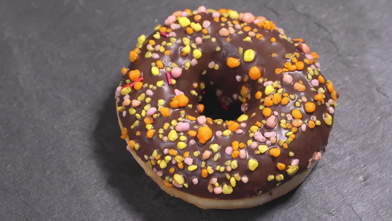 el donut dulce gira sobre un fondo oscuro. la dulzura tradicional estadounidense
