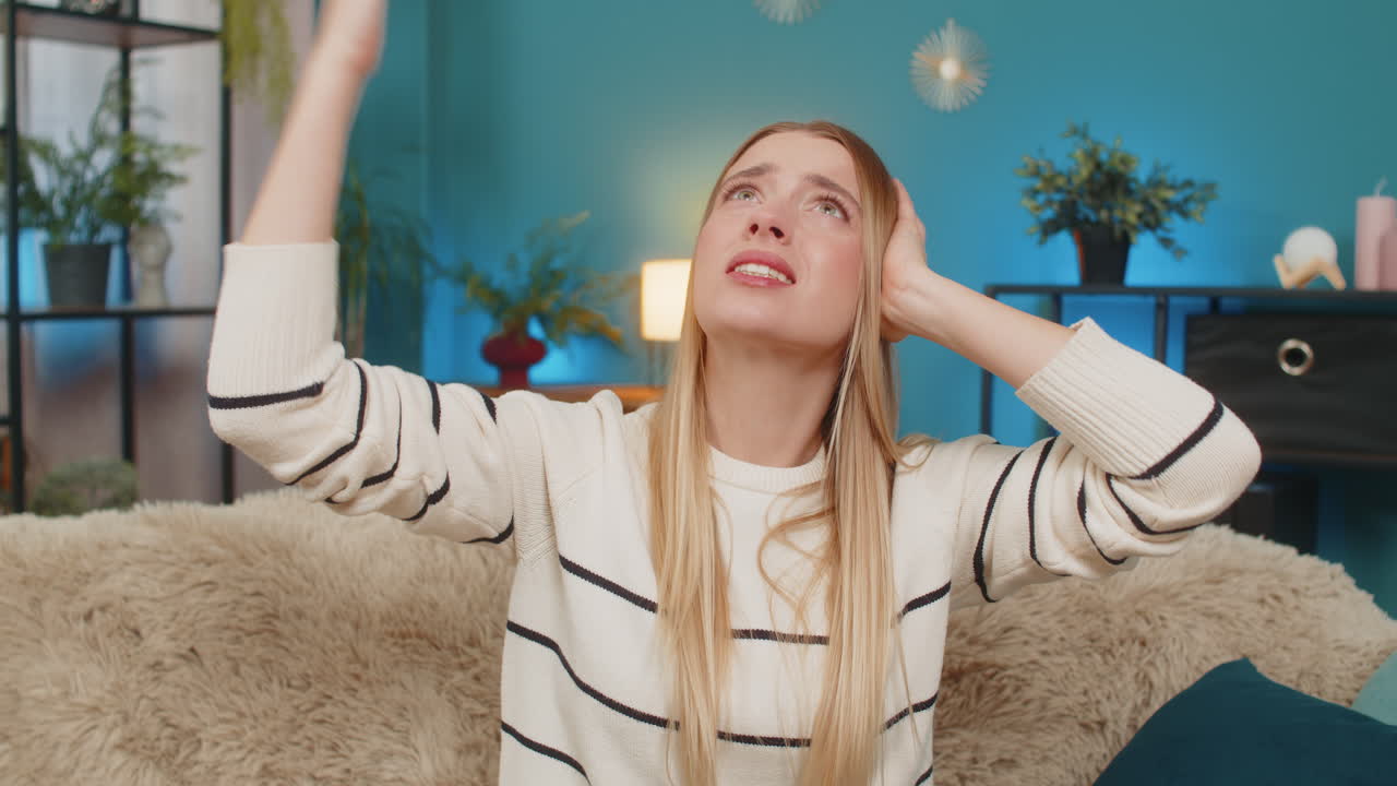 소란스러운 이웃에 의해 짜증나는 백인 여성 소파 건설에 귀를 고 실내에서 큰 소리로 음악