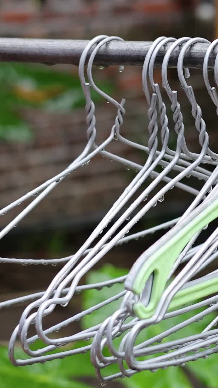 mano arreglando colgadores de ropa blanca en un estante