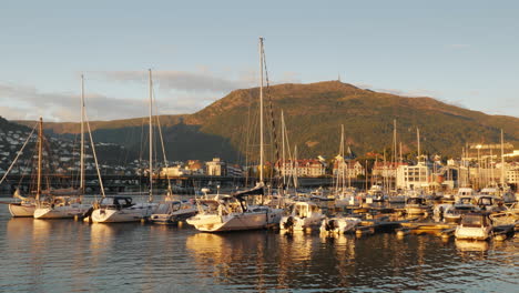 a number of small yachts are moored in a picturesque place in the background of the mountain the cit