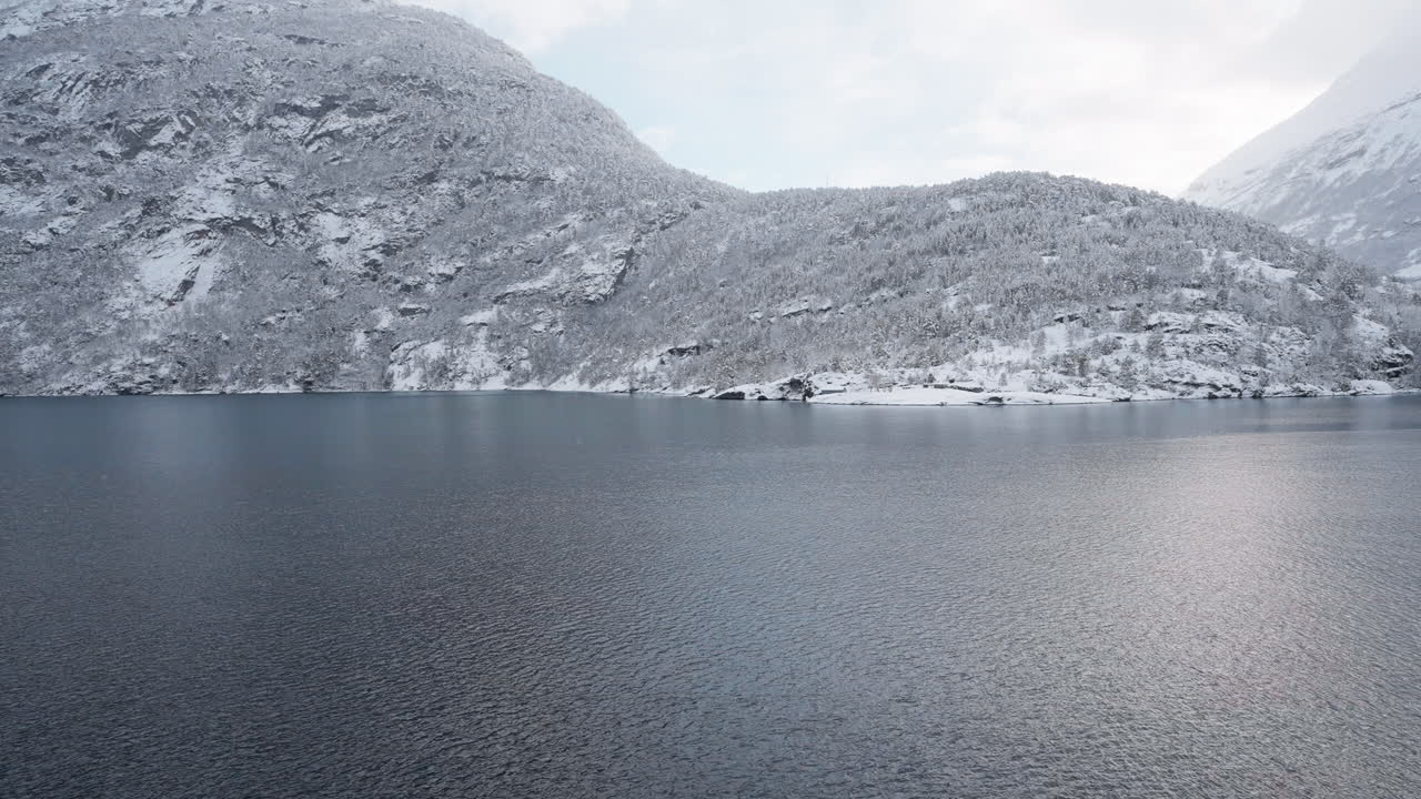 película en cámara lenta de un paseo en ferry de invierno en geirangerfjord a geiranger, noruega, con montañas nevadas y cautivadoras vistas del fiordo