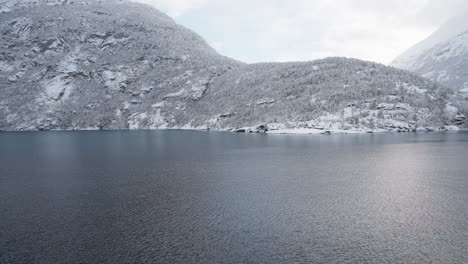 slow motion pov of a winter ferry boat ride in geirangerfjord to geiranger, norway, with snowy mountains and captivating fjord views