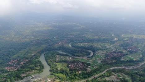 winding river and towns in indonesia landscape, aerial drone view