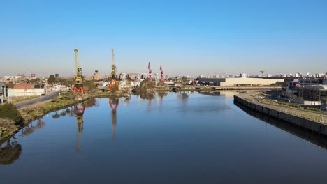 vuelo a lo largo de riachuelo contaminado mostrando grúas industriales