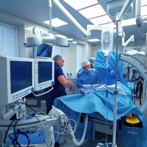 surgery in hospital. specialists providing operation with modern technology equipment in hospital. back view of doctors looking on monitor during operation