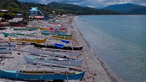 drone shot with parallax of fishing boats on shore of mabua beach, surigao philippines