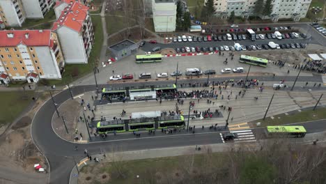 Drone-view-of-a-tram-loop-and-a-crowd-of-people-surrounded-by-a-residential-housing-estate