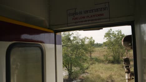 pov shot from train of landscape passing by from thailand's eastern line from bangkok to ban klong luk during the day in thailand, medium shot