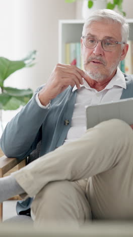 a senior man sitting in a chair, looking at the camera, thinking