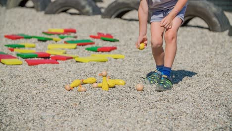 young boy playing with figures in gravel on a playground