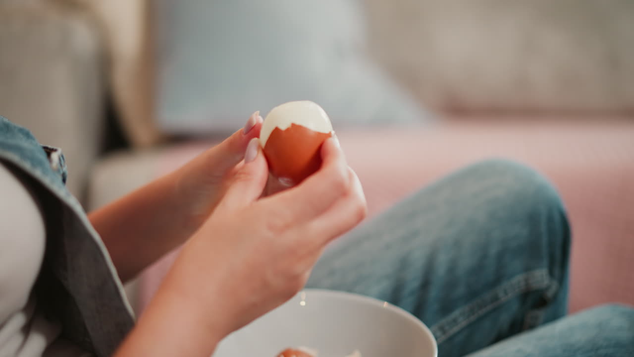 Woman peeling a boiled egg