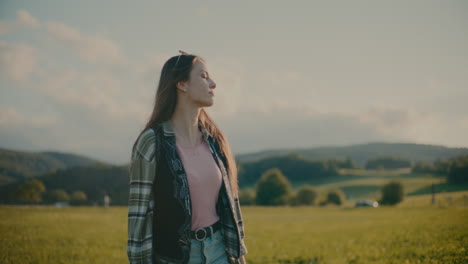 smiling woman with sunglasses walking in meadow