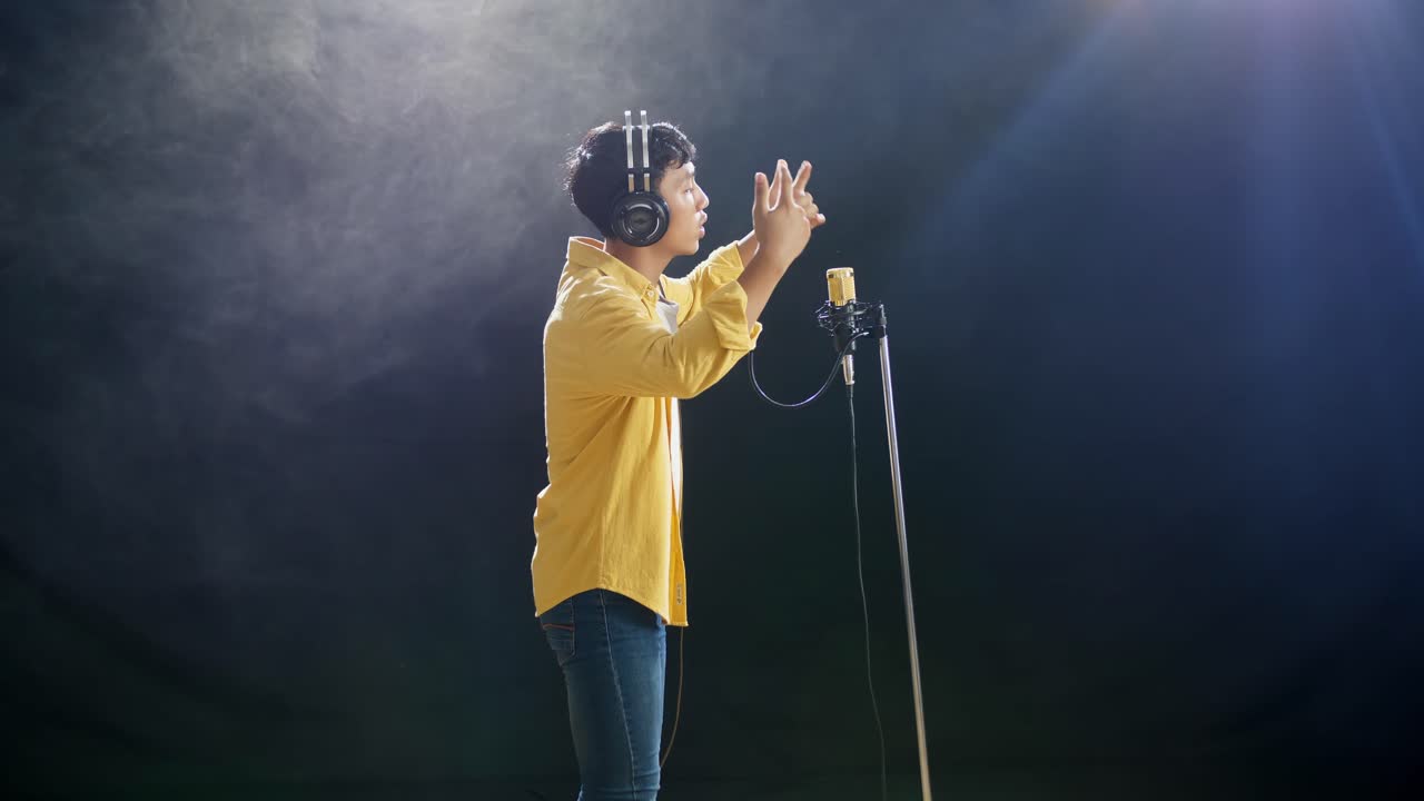 hombre cantando en un micrófono en un estudio de grabación