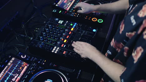 dj mixing music on a console at a nightclub