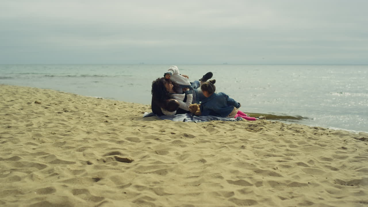 padres y hijos disfrutando de unas vacaciones en la playa junto a un mar tranquilo.