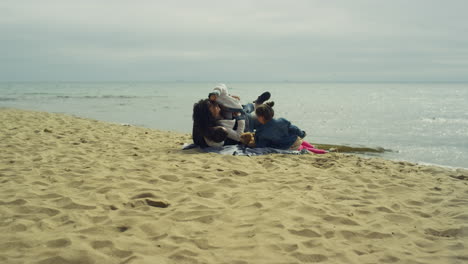 Parents-kid-enjoying-beach-vacation-by-calm-sea.-Family-play-around-on-picnic.