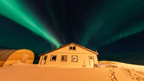 timelapse, green vibrant northern lights display above house, iceland