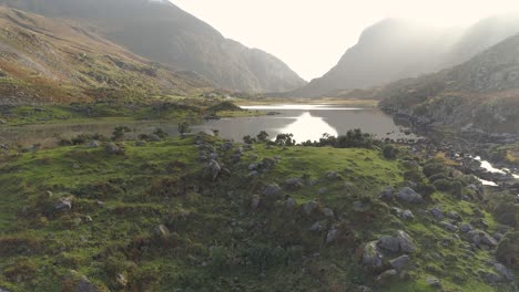 aerial of stunning epic rocky landscape birds flying by, at lake, mountains and greend and brown thrilling nature gap of dunloe ireland