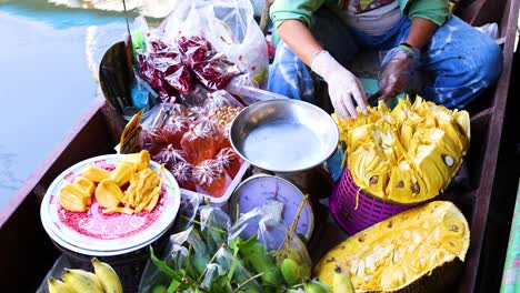 vendor selling fruit on a boat in bangkok