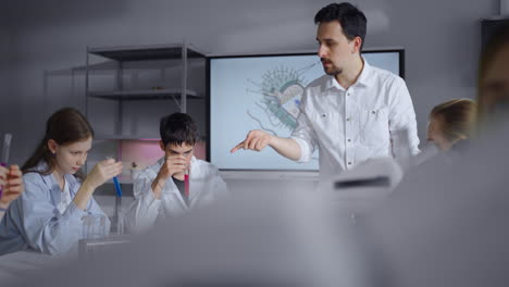 teacher explains biology to students in the lab